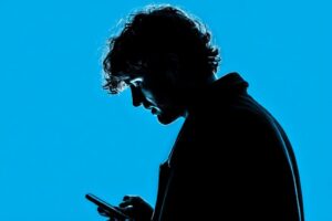 ddmmtry_A_30yo_man_wathching_into_smartphone_screen_siluett_por_d8fc4857-0524-4f34-9b10-1a080066ad48