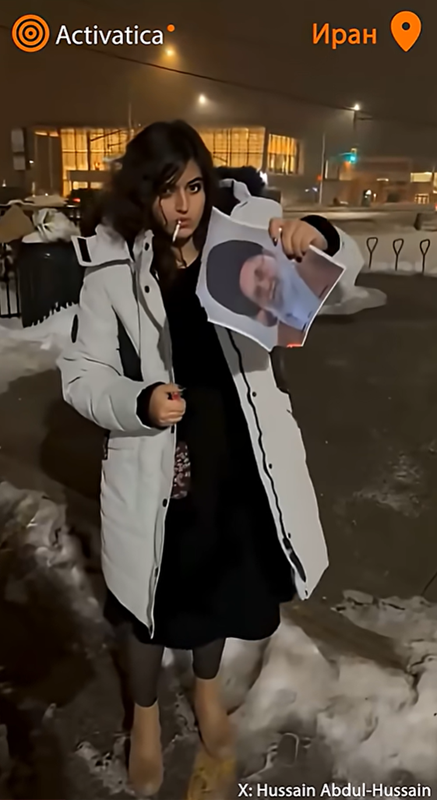 Протесты в Иране девушка прикуривает сигарету от портрета Хаменеи